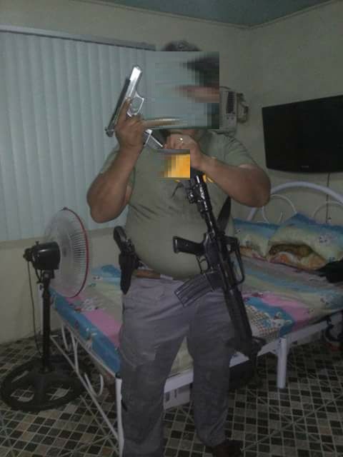 a man holding an m16 rifle with pistol on hand.jpeg